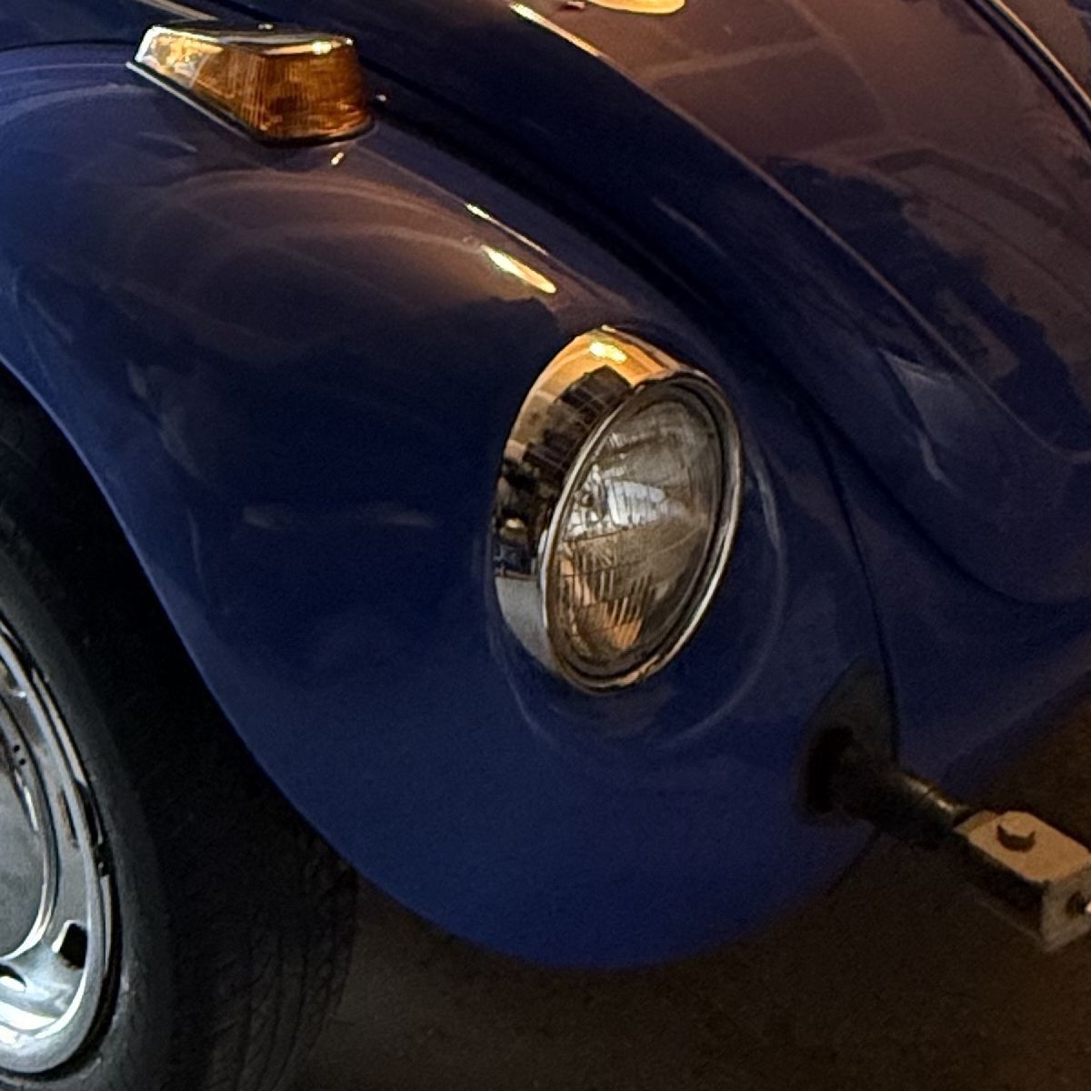 Close detail of the chrome headlight and amber turn signal on the front fender